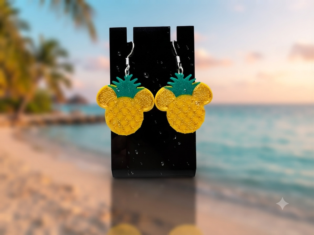 Mausohren Ananas Ohrringe aus 3D-Druck in Gelb und Grün mit 925er Silberhaken, auf schwarzem Schmuckdisplay vor tropischer Strandkulisse – von fks-design
