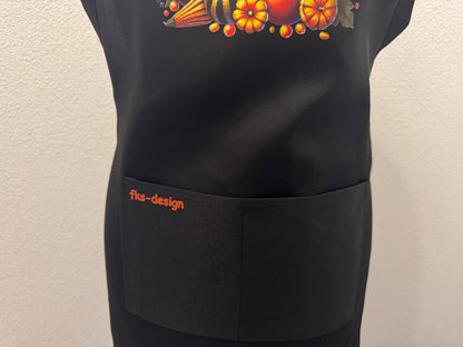Detailansicht schwarze Kochschürze "Herbst Vibes" mit Kürbis-DTF-Druck und fks-design Schriftzug auf der Tasche – von fks-design

